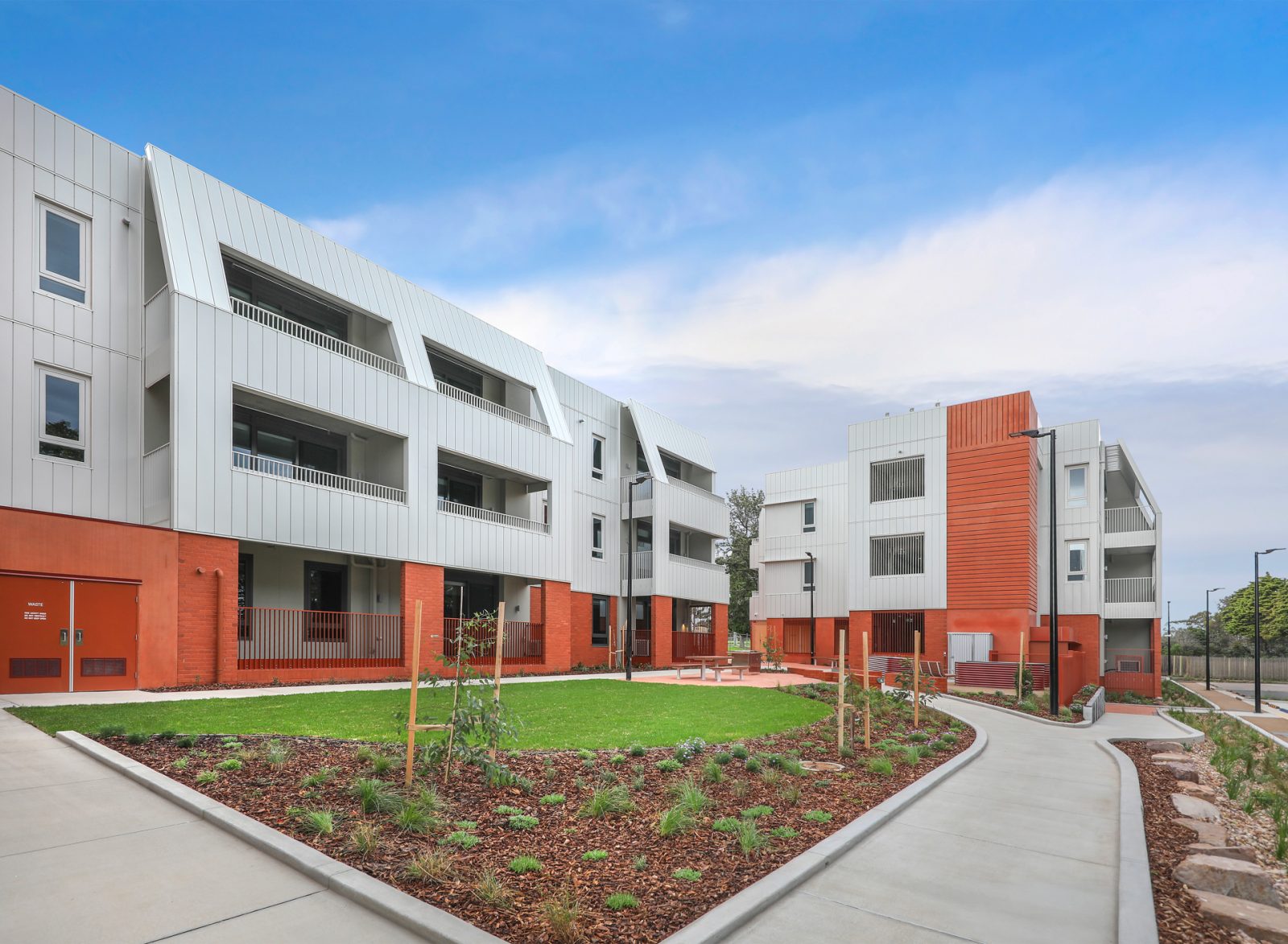 Completed Big Housing Build apartment development with landscaped courtyard, native gardens and lawn, East Geelong.